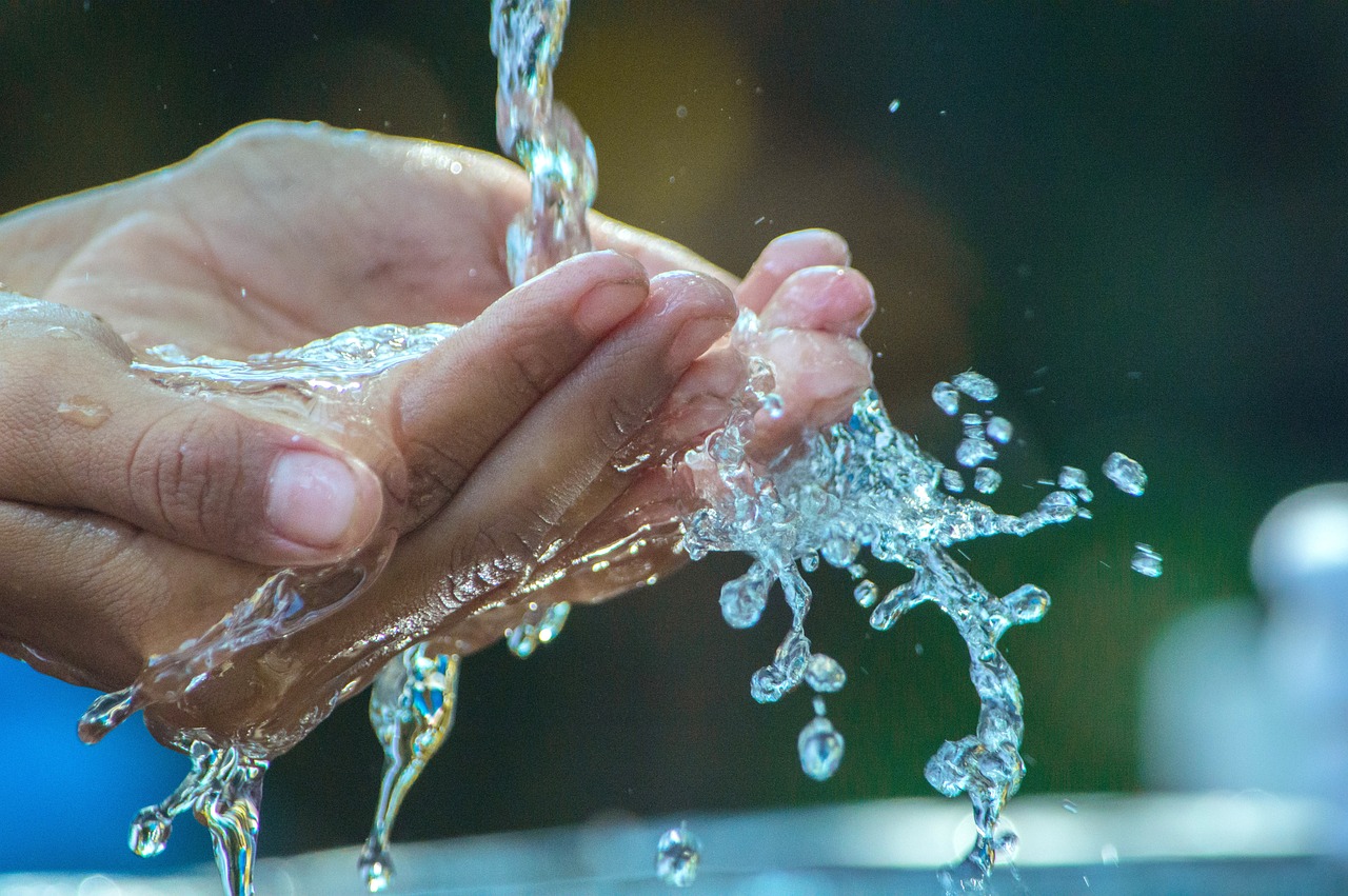 Mani sotto rubinetto d'acqua